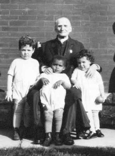 Father Baker with some of the children he helped through his many charities.